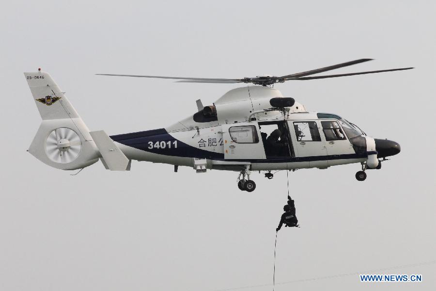 Special armed police take part in a drill with a police helicopter in Hefei, capital of east China's Anhui Province, July 18, 2012. The helicopter with functions for police guard and fire fighting started its official cruise in Hefei on Wednesday. (Xinhua/Zhang Duan) 