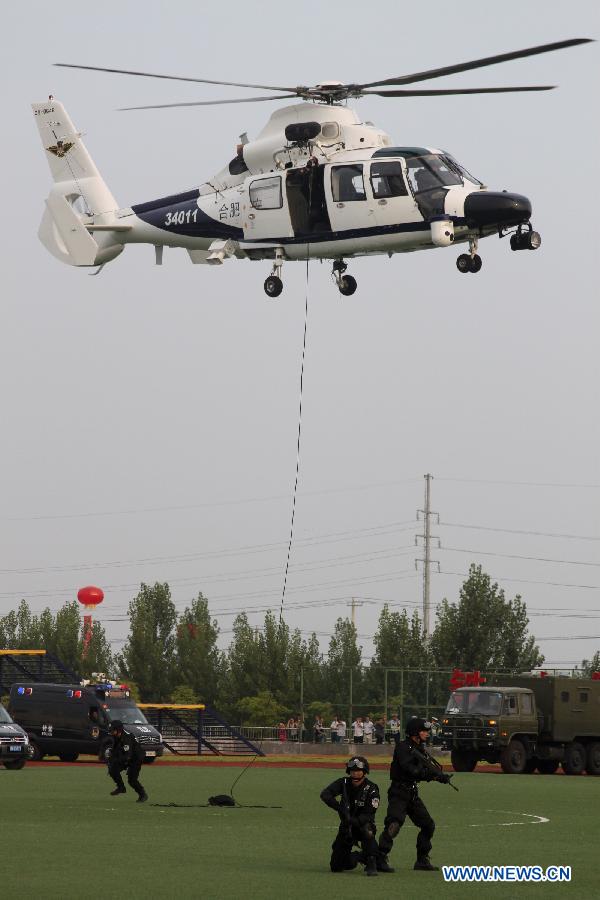 Special armed police take part in a drill with a police helicopter in Hefei, capital of east China&apos;s Anhui Province, July 18, 2012. The helicopter with functions for police guard and fire fighting started its official cruise in Hefei on Wednesday. (Xinhua/Zhang Duan) 