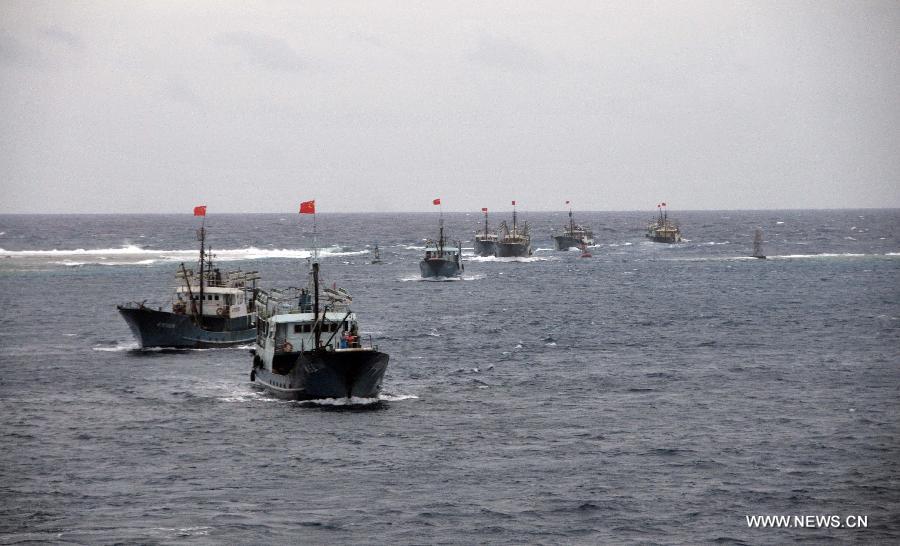 Fishing vessels sail into the lagoon of Meiji Reef of south China Sea on July 20, 2012. The fleet of 30 boats, including a 3,000-tonne lead boat carrying fresh water, fuel and other supplies, sailed into the lagoon of Meiji Reef to take shelter from storm at about 6 p.m. Friday. The fleet has sailed past Sanya and Yongshu, Zhubi and Meiji reefs. [Xinhua]