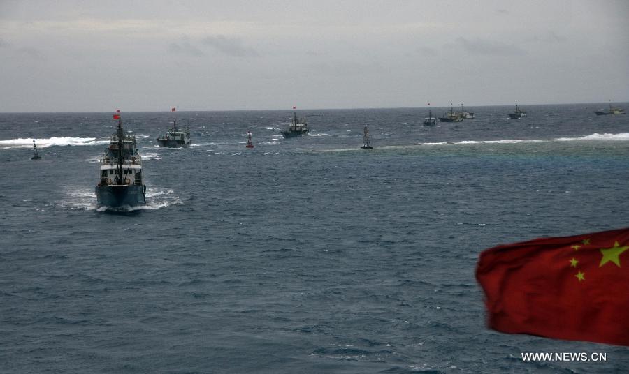 Fishing vessels sail into the lagoon of Meiji Reef of south China Sea in turn on July 20, 2012. The fleet of 30 boats, including a 3,000-tonne lead boat carrying fresh water, fuel and other supplies, sailed into the lagoon of Meiji Reef to take shelter from storm at about 6 p.m. Friday. The fleet has sailed past Sanya and Yongshu, Zhubi and Meiji reefs. [Xinhua]