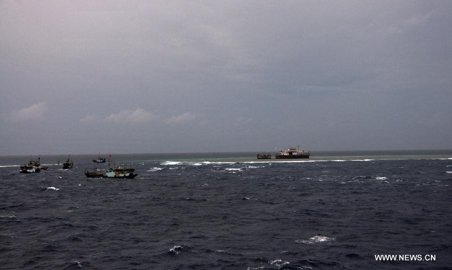 Fishing vessels arrive at Meiji Reef of south China Sea on July 20, 2012. The fleet of 30 boats, including a 3,000-tonne lead boat carrying fresh water, fuel and other supplies, sailed into the lagoon of Meiji Reef to take shelter from storm at about 6 p.m. Friday. The fleet has sailed past Sanya and Yongshu, Zhubi and Meiji reefs. [Xinhua]