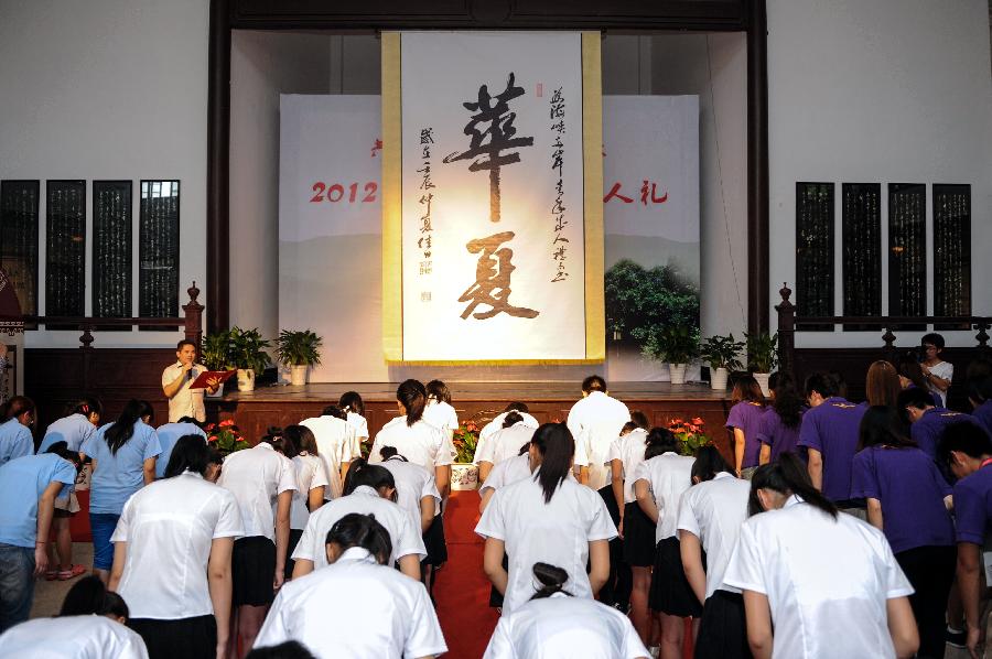 Students from the both sides of the Taiwan Strait take a bow as they attend a coming-of-age ceremony in Fenghua, east China's Zhejiang Province, July 20, 2012. A coming-of-age ceremony was held here Friday, in which 30 students from southeast China's Taiwan and 50 mainland students took part. [Xinhua]