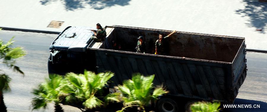 Picture taken on July 22, 2012 shows a truck carrying Syrian soldiers drives along a street of Damascus. A pro-government Syrian TV said the government troops cleansed armed fighters from another neighborhood of the capital Damascus on Sunday after 24 hours of intense fighting. (Xinhua) 