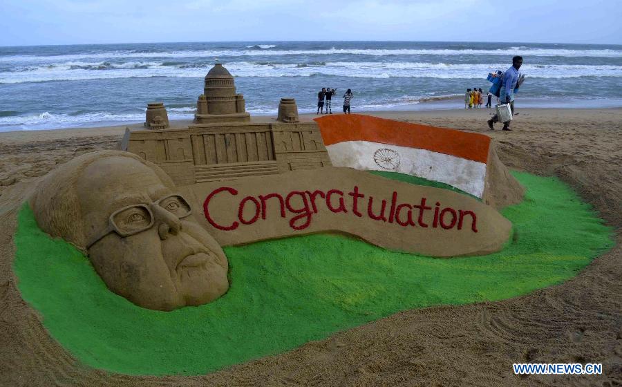 A visitor goes past a sand sculpture of the newly elected Indian President Pranab Mukharjee in the golden sea beach at Puri, 65 km away from the Bhubaneswar, capital city of the eastern Indian state Orissa, July 22, 2012. India's Congress heavyweight and former finance minister Pranab Mukherjee has been elected the 13th president of India, according to the outcome of official accounts of votes Sunday. (Xinhua) 