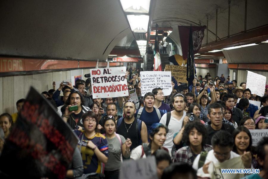 Residents walk into a subway station during a demonstration protesting against the outcome of the July 1 general elections, in Mexico City, capital of Mexico, on July 22, 2012. Protesters marched to the Zocalo in downtown Mexico City. Thousands of demonstrators marched through Mexico City on Sunday to protest the outcome of the July 1 general elections, which declared Institutional Revolutionary Party (PRI) presidential candidate Enrique Pena Nieto the winner. (Xinhua/Rodrigo Oropeza) 