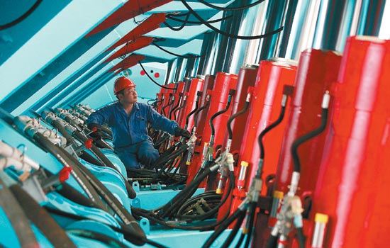 A worker at an electromechanical equipment workshop in Huaibei, Anhui province. The output of China's machinery industry increased 12.17 percent year-on-year in the first half of the year, much slower than at the same time last year. [Photo/China Daily]