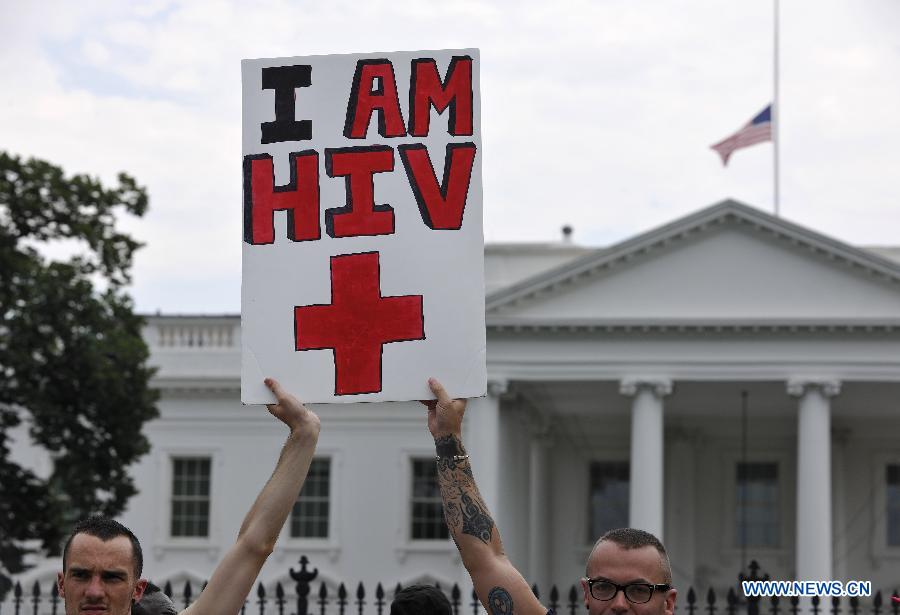 Protestors hold up a placard reading 'I am HIV +' outside the White House during AIDS Parade in Washington D.C., capital of the United States, July 24, 2012. Thousands of people gathered around the Washington Convention Center where the 19th International AIDS Conference is convened and walked to the White House, asking the U.S. governmant for more attention to AIDS medical care and elimination of the discrimination against HIV Possitives. (Xinhua/Zhang Jun) 