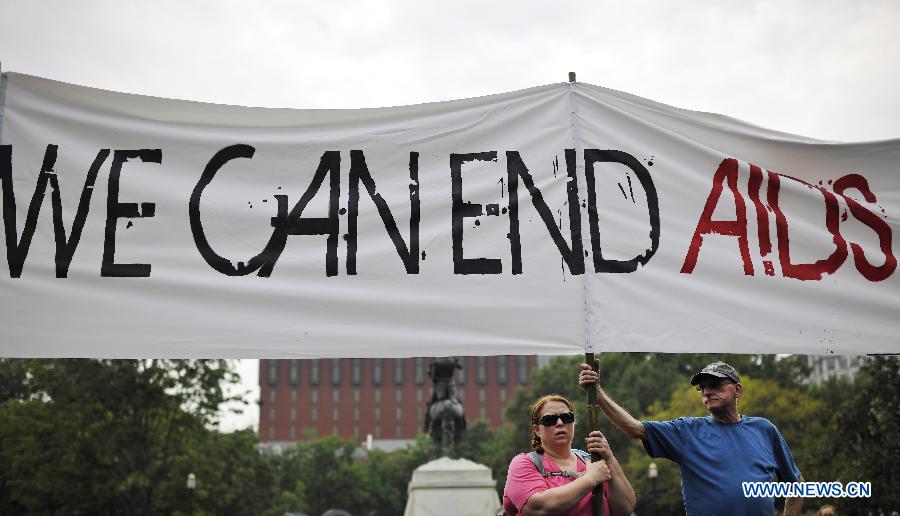 Protestors hold up slogans reads 'We can end AIDS' outside the White House during AIDS Parade in Washington D.C., capital of the United States, July 24, 2012. Thousands of people gathered around the Washington Convention Center where the 19th International AIDS Conference is convened and walked to the White House, asking the U.S. governmant for more attention to AIDS medical care and elimination of the discrimination against HIV Possitives. (Xinhua/Zhang Jun) 