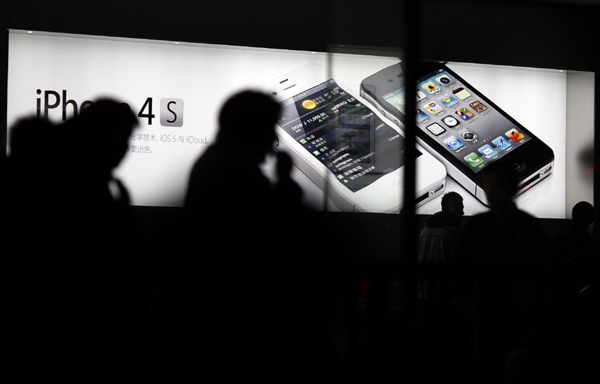 Customers wait in line to buy the new iPhone 4S at Apple's retail store in downtown Shanghai, Jan 13, 2012.