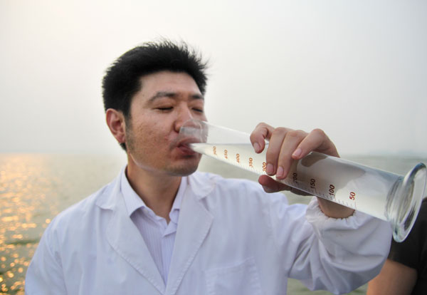 A worker in charge of monitoring water quality drinks a sample from Weishan Lake in Shandong province, on July 18. The quality of the lake water is up to Grade III, a standard fit for drinking.