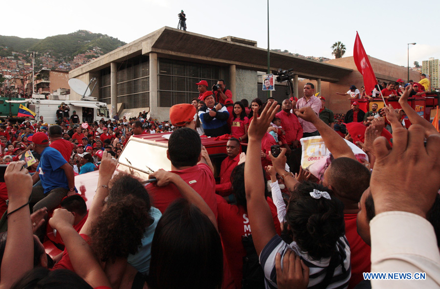 Venezuelan President and presidential candidate Hugo Chavez (C) greets his supporters during a caravan at El Valle parish, in Caracas, capital of Venezuela, on July 26, 2012. Chavez and opposition candidate Henrique Capriles will compete in the presidential election on Oct. 7, 2012. (Xinhua/AVN) 