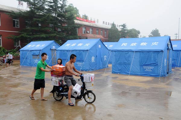 Flood-affected residents of Beicheying Village, Qinglonghu Township receive relief foodstuffs in Fangshan District, a suburb of Beijing, capital of China, July 26, 2012. [Photo/Xinhua]