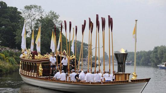 The cauldron for the Olympic Flame on the Royal rowbarge Gloriana as it makes it way down the River Thames towards Tower Bridge on its final day.       Sir Matthew Pinsent lights the cauldron with the Olympic Flame on the Royal rowbarge Gloriana as it makes it way down the River Thames towards Tower Bridge.    