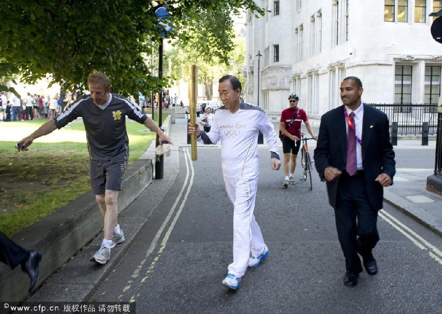 Secretary-General Ban Ki-moon (centre) takes part in the torch run, seen here in a photo released by the United Nations, for the 2012 Summer Olympic Games in London. [CFP]