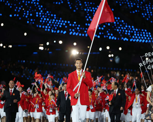 China's flag-bearer Yi Jianlian, center, holds the national flag as he leads the Chinese contingent in the athletes parade during the opening ceremony of the London 2012 Olympic Games at the Olympic Stadium in London, July 27, 2012. [Photo/Xinhua]