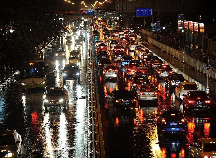 Vehicles run on the road as rain hit Beijing, capital of China, July 27, 2012. A new round of torrential rain pelted the capital Friday evening.