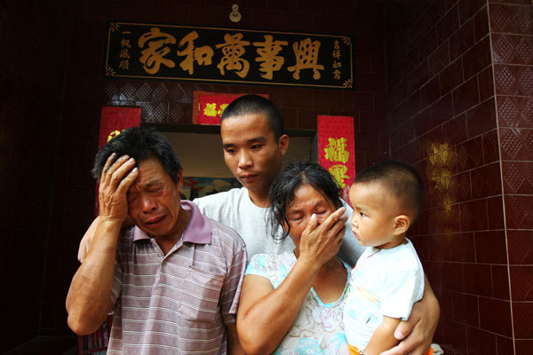 Li Guoqi comforts his parents in Pingdingshan, Henan province, on Wednesday. Li and his fellow fishermen were rescued on July 17 after being held hostage by Somali pirates for 19 months. Photo / China News Service 