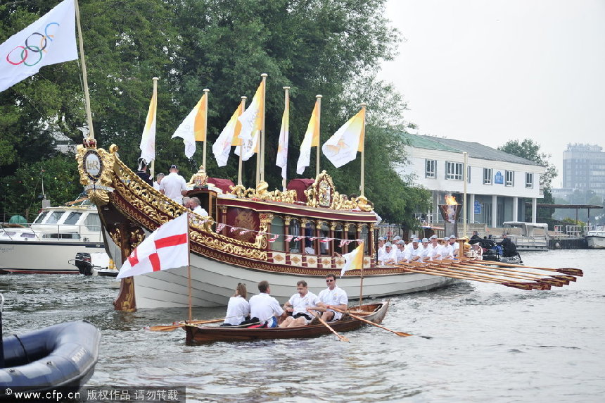 The Olympic flame is carried by the Royal Barge Gloriana on its route along the River Thames from Hampton Court to the Olympic stadium in Stratford, East London ahead of the start of the Olympic Games in the capital. [CFP]