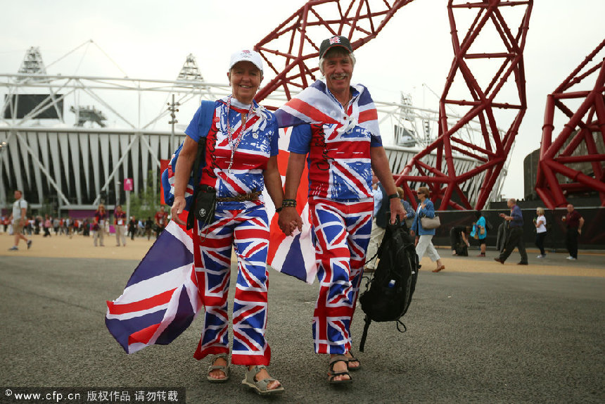 Great Britain fans dressed in Union Jack clothing walk outside the Olympic stadium during the Olympics Opening Day as part of the London 2012 Olympic Games at the Olympic Park on July 27, 2012 in London, England. [CFP]