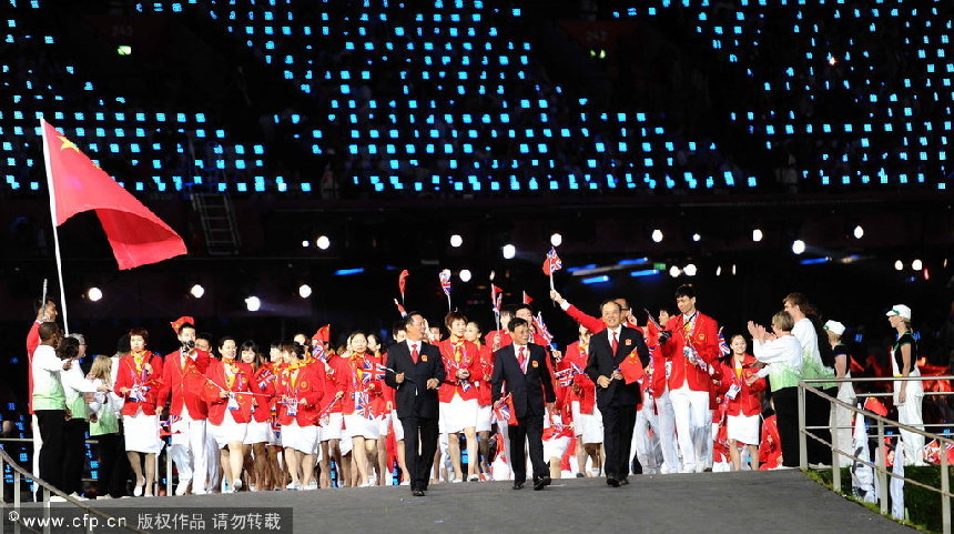 Flag bearer Yi Jianlian of China leads the team into the Olympic Stadium during the Opening Ceremony of the London 2012 Olympic Games, London, Britain, 27 July 2012. [CFP]