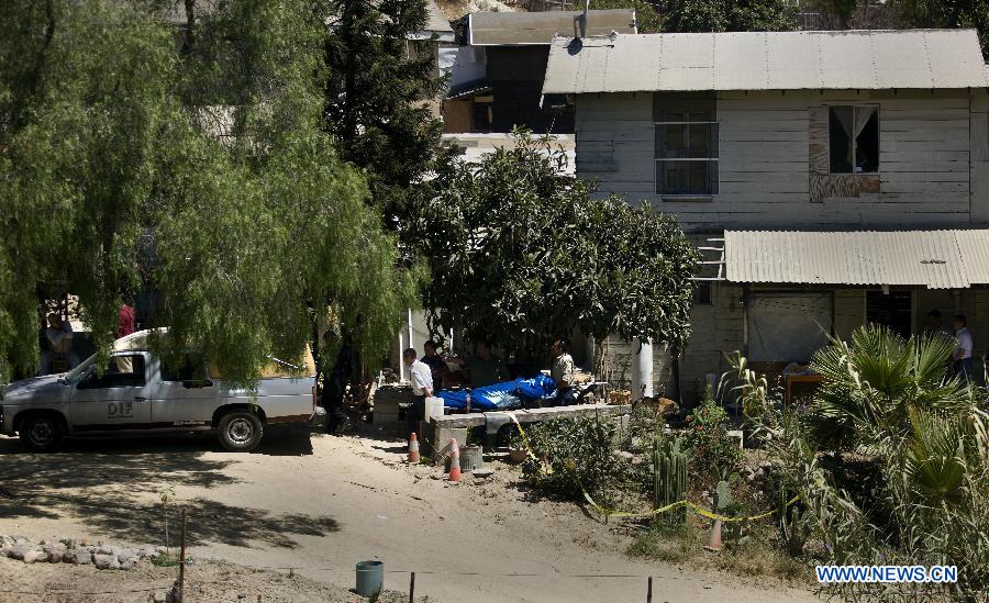 Members of the Mexican Coroner Service remove a body at the crime scene where two men were killed inside a house in Tijuana, northeast Mexico, July 28, 2012. Two high-caliber weapons were found at the crime scene. (Xinhua/Guillermo Arias)