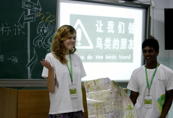 Amelia Dmowska and Rakesh Goli, high school students from the United States, deliver a presentation on a proposal to standardize English signs at public places during a model political consultative conference in Beijing on Friday.
