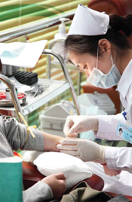 Collecting blood at a blood donation center in Xidan in downtown Beijing in March. Acknowledging that lesbians are low-risk donors, the Ministry of Health revised the regulation introduced in 2001 that prohibited all homosexuals from giving blood.[ Photo / China Daily ]