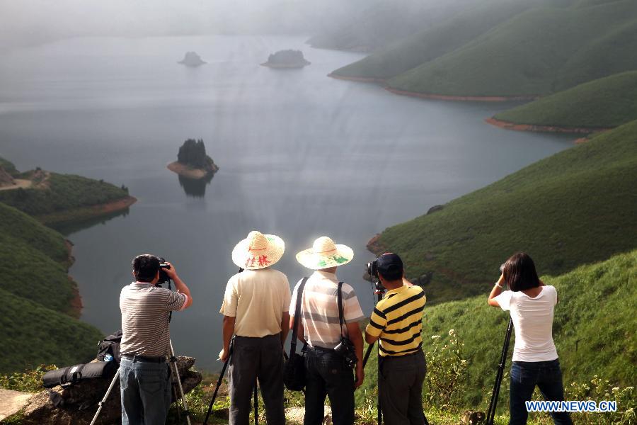 Photo fans take pictures in Tianhu Scenic Spot of Quanzhou County, south China's Guangxi Zhuang Autonomous Region, July 29, 2012. The Tianhu Scenic Spot, with the height of over 1,600 meters above sea level, is a lake district containing 13 reservoirs and high mountain forests. (Xinhua/Wang Zichuang) 