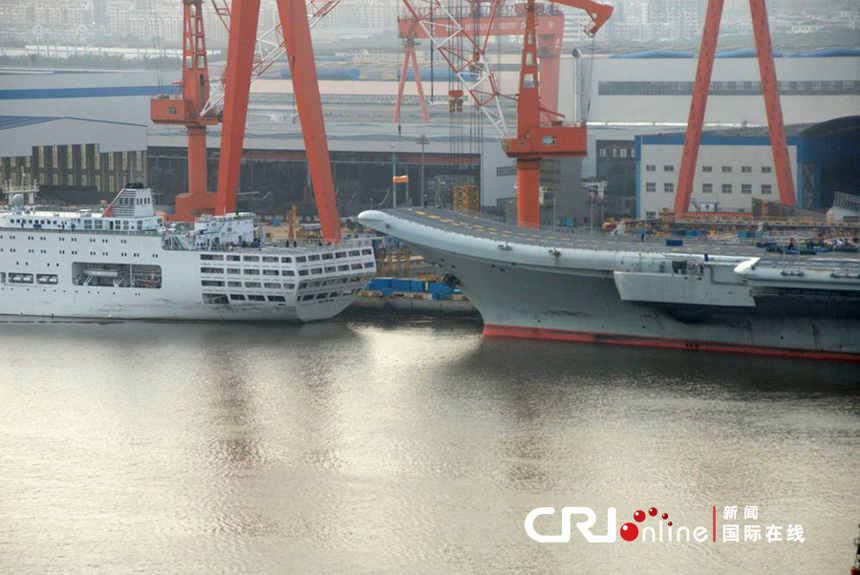 China's aircraft carrier platform returns to the dock in Dalian, northeast China's Liaoning Province, after finishing its 9th sea trial, July 30, 2012. The trial lasted 25 days, the longest one in its history.