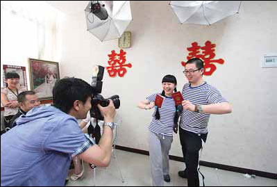 Two newlyweds pose wearing the Haihunshan, the PLA Navy's latest uniform, in Chongqing. [ Photo / China Daily ]