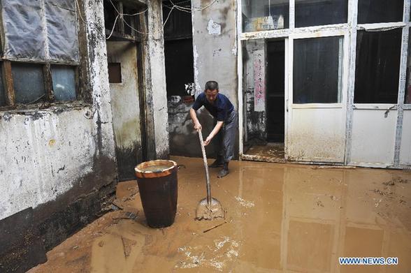 A villager clears mud in his waterlogged home in Jincheng, north China's Shanxi Province, July 31, 2012. Many places in Shanxi witnessed rainy weather from Monday to Tuesday, and the provincial meteorological center has issued a red alert for thunderstorms in southern region of the province. 