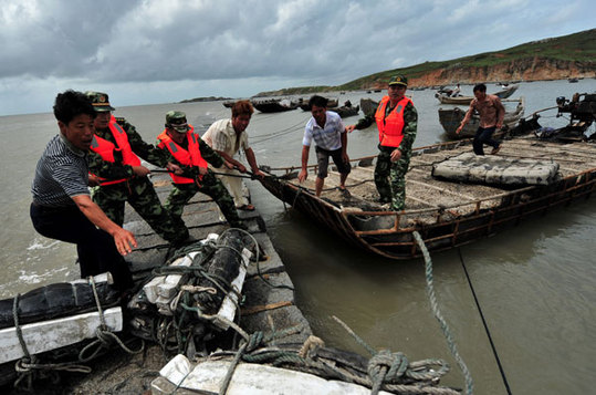 Border guards help fishermen secure their boats at a port in Fuqing, Fujian province, on Tuesday. Tropical storm Saola is expected to hit Fujian and Zhejiang provinces on Thursday or Friday. [Xinhua]
