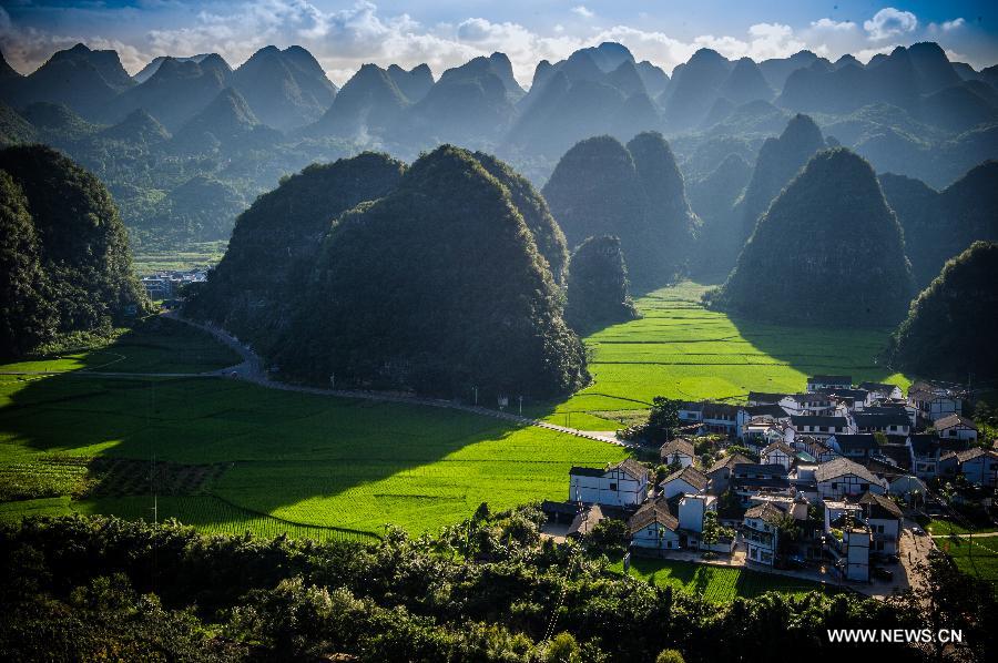 A visitor takes photos of Wanfenglin in Xingyi, southwest China's Guizhou Province, July 31, 2012. Wanfenglin, which literally means Forest of Ten Thousand Peaks, is a national geological park and also a tourism attraction in Xingyi City. (Xinhua/Liu Xu)