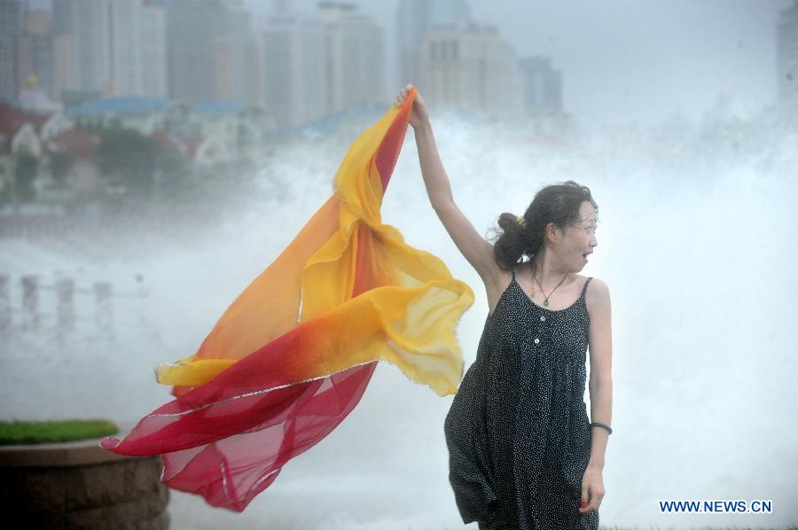A girl waves her shawl on the shore as the Typhoon Saola approaches in Qingdao, east China's Shandong Province, Aug. 3, 2012. Shandong Provincial Meteorological Station has issued the red alert for the Typhoon Saola, the highest warning level in China's four-tier weather warning system. (Xinhua/Li Ziheng) 