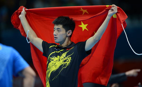 Zhang Jike of China holds Chinese national flag after winning in men's table tennis singles final match against Wang Hao of China, at London 2012 Olympic Games in London on August 2, 2012. Zhang Jike of China won gold medal. 