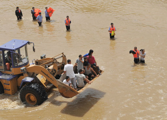 People are moved to safety in Gaizhou, Liaoning province, on Saturday after flooding triggered by torrential rain brought by Typhoon Damrey. The 10th typhoon of the year disrupted service on three railways in the province on Saturday morning, local authorities said. [China Daily] 