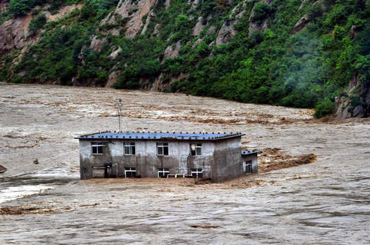 Buildings are inundated in flood water in Nanfen areas of Benxi, Northeast China's Liaoning province, August 4, 2012. Flooding triggered by torrential rain brought by Typhoon Damrey, the 10th typhoon of the year, disrupted services of three railways in Liaoning province. Rescue is underway. [Xinhua]