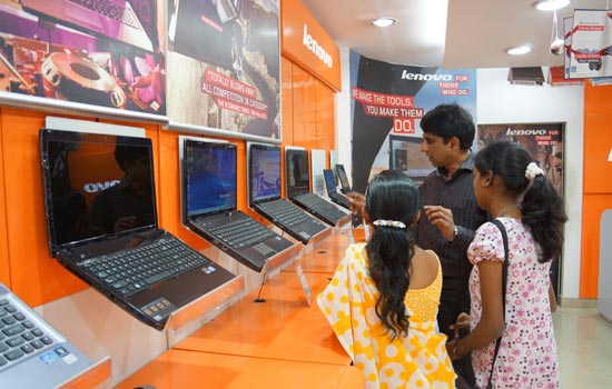 Lenovo-exclusive store owner S. Habeeb (center) showing his customers Lenovo laptop products in his Bangalore store. Two months ago, Lonovo introduced its tablet PC to the Indian market. [Photo/China Daily] 