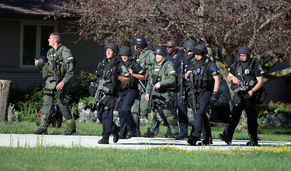 Law enforcement personnel walk near the Sikh Temple of Wisconsin where at least one gunman fired upon people at a service on August, 5, 2012 Oak Creek, Wisconsin. At least six people were killed when a shooter, who was later shot dead by a police officer, opened fire on congregants in the Milwaukee suburb. [Xinhua]