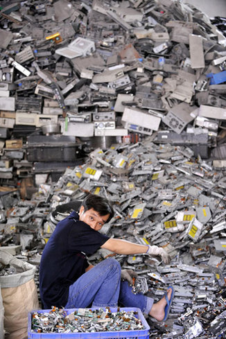 A worker at an e-waste disposal workshop in Shantou, Guangdong province, has a rest on May 31. [Xinhua] 