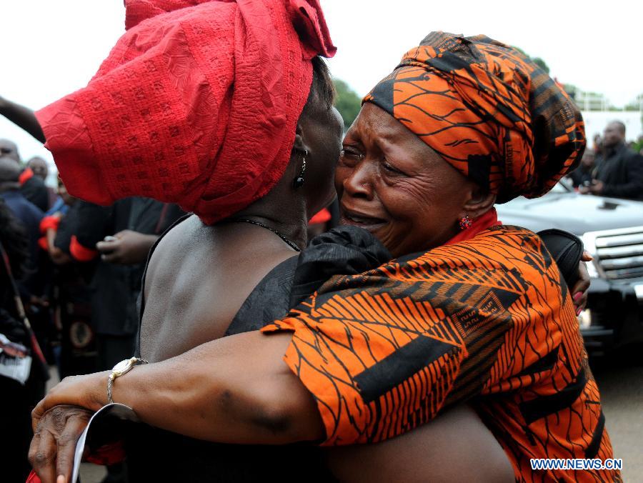 ACCRA, Aug. 8, 2012 (Xinhua) -- Two Ghanaian women weep outside the State Banquet Hall after they bid farewell to the remains of Ghana's late president John Evans Atta Mills in Accra, capital of Ghana, on Aug. 8, 2012. The late President Mills, 68, died suddenly on July 24, at the 37th Military Hospital after falling ill. (Xinhua/Shao Haijun) 