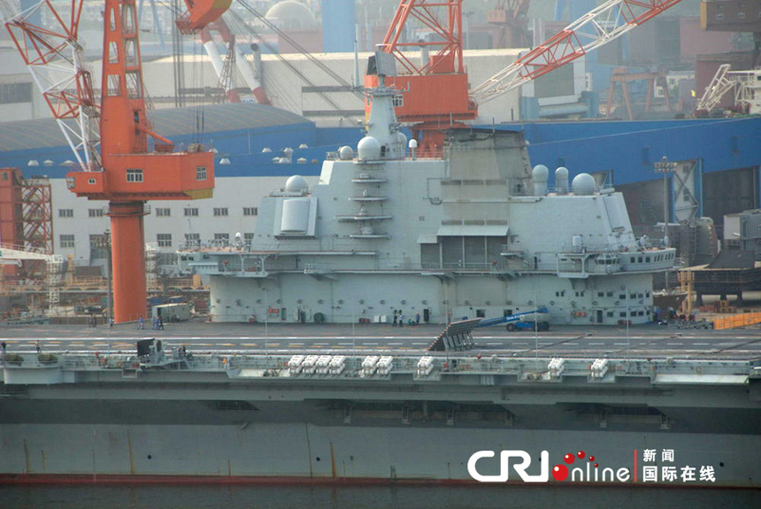 China's aircraft carrier platform returns to the dock in Dalian, northeast China's Liaoning Province, after finishing its 9th sea trial, July 30, 2012. The trial lasted 25 days, the longest one in its history.
