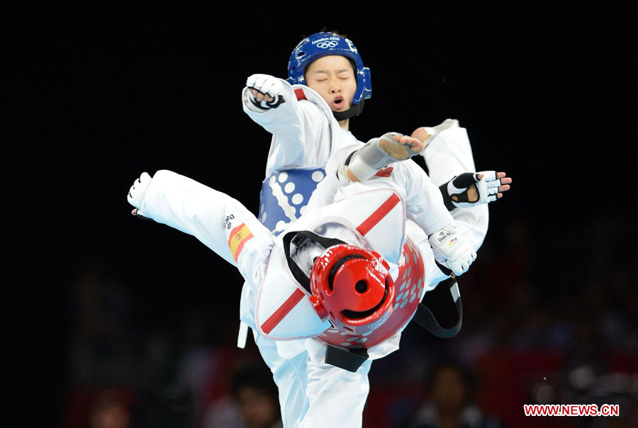 China's Wu Jingyu (up) competes with Brigitte Yague Enrique of Spain during women's -49 kg taekwondo gold medal match at London 2012 Olympic Games, London, Britain, Aug. 8, 2012. Wu Jingyu won the match 8-1 and won gold medal in this event. [Liu Dawei/Xinhua]