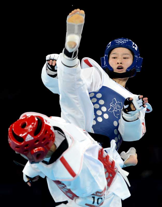 China's Wu Jingyu (up) competes with Brigitte Yague Enrique of Spain during women's -49 kg taekwondo gold medal match at London 2012 Olympic Games, London, Britain, Aug. 8, 2012. Wu Jingyu won the match 8-1 and won gold medal in this event. [Li Gang/Xinhua]