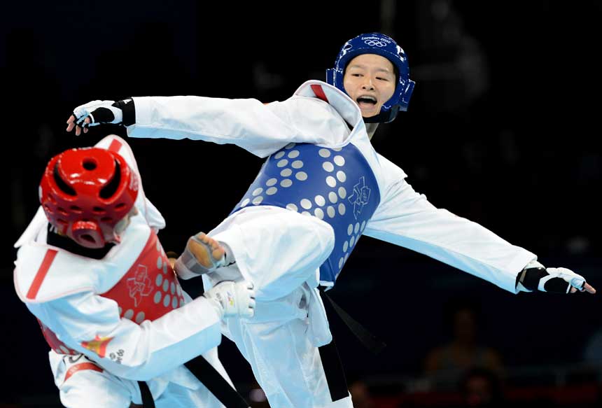 China's Wu Jingyu (R) competes with Brigitte Yague Enrique of Spain during women's -49 kg taekwondo gold medal match at London 2012 Olympic Games, London, Britain, Aug. 8, 2012. Wu Jingyu won the match 8-1 and won gold medal in this event. [Li Gang/Xinhua]