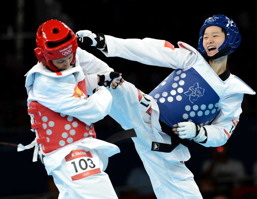 China's Wu Jingyu (R) competes with Brigitte Yague Enrique of Spain during women's -49 kg taekwondo gold medal match at London 2012 Olympic Games, London, Britain, Aug. 8, 2012. Wu Jingyu won the match 8-1 and won gold medal in this event. [Li Gang/Xinhua]