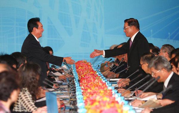 Chen Yunlin (L), president of the Chinese mainland-based Association for Relations Across the Taiwan Straits, and Chiang Pin-kung (R), chairman of the Taiwan-based Straits Exchange Foundation, reach out to shake hands before starting their eighth round of meeting since 2008, in Taipei, southeast China's Taiwan, Aug. 9, 2012.