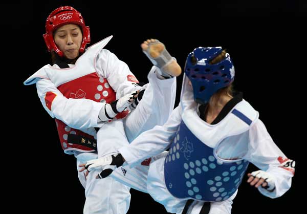 China's Hou Yuzhuo (L) competes with Jade Jones of Britain during women's -57 kg taekwondo final at London 2012 Olympic Games, London, Britain, Aug. 9, 2012. Hou fell to Jones 6-4 and won silver medal in this event. [Wang Lili/Xinhua]