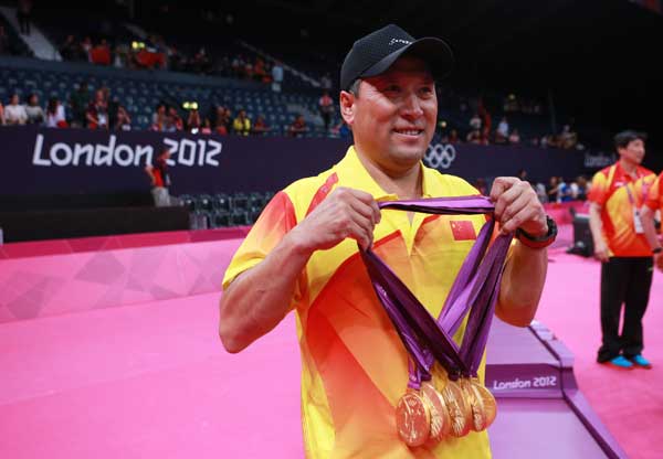 Chinese badminton head coach Li Yongbo poses with all five gold medals Chinese badminton team got at the London Olympic Games. [Ren Zhenglai/Xinhua]