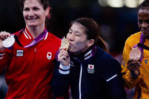 Janpan wrestling legend Saori Yoshida (C) kisses her gold medal after winning women's 55kg freestyle final match at the London Olympic Games on August 9, 2012. [Jin Liwang/Xinhua]